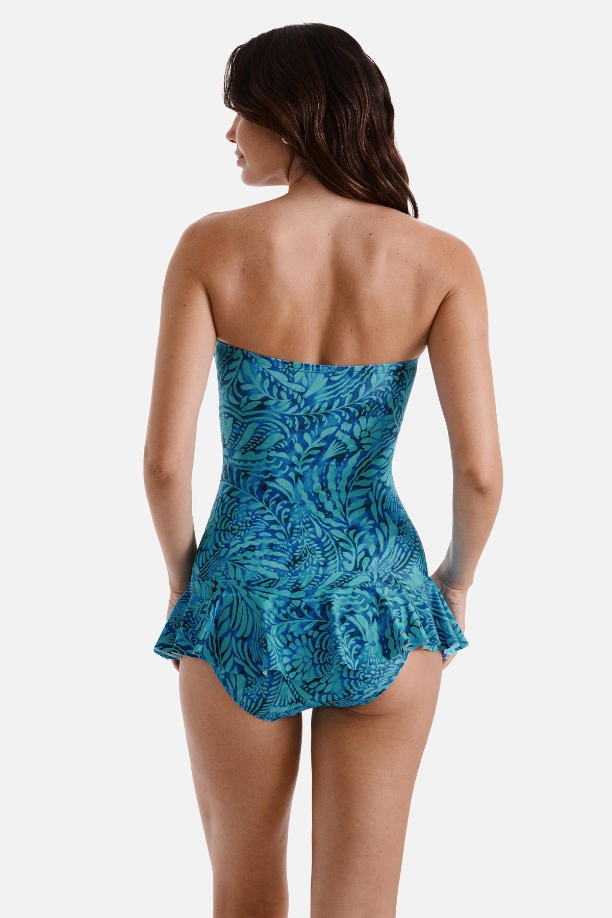 Woman turned away wearing a blue abstract printed skirted one-piece swimsuit