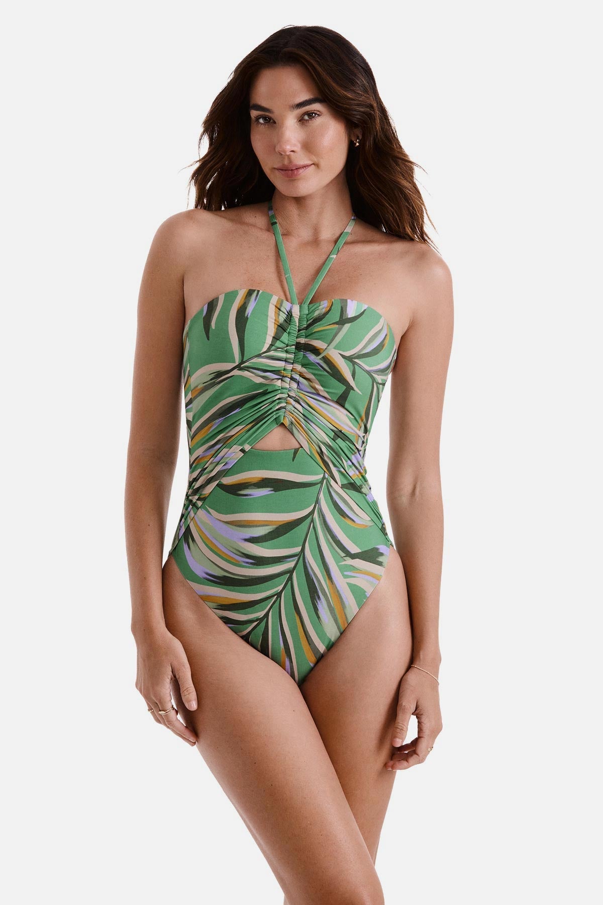 Woman wearing a multicolored leaf printed one-piece swimsuit with a halter tie