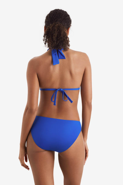 Woman faced away wearing a blue bikini top with matching swim bottoms