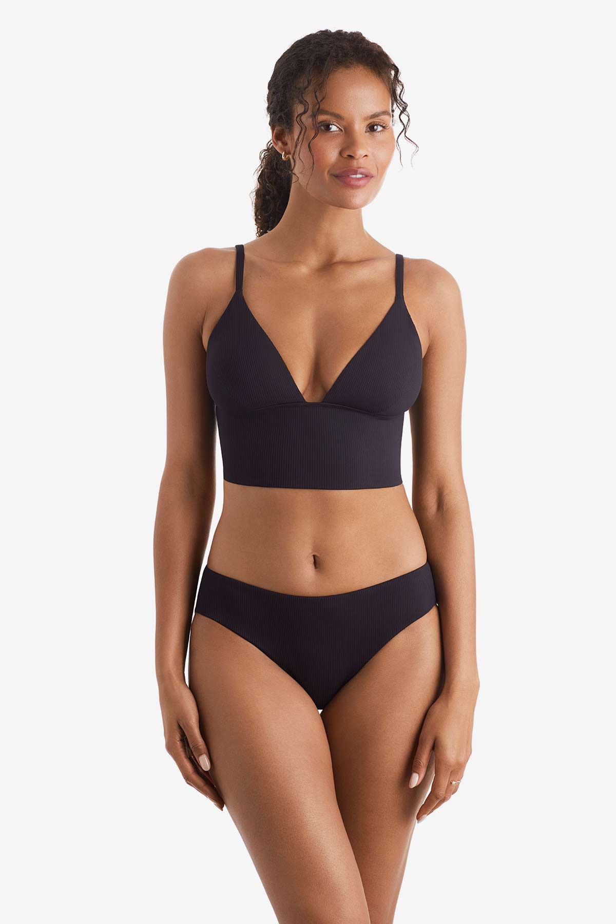 Woman wearing a black midkini swim top with black swim bottoms