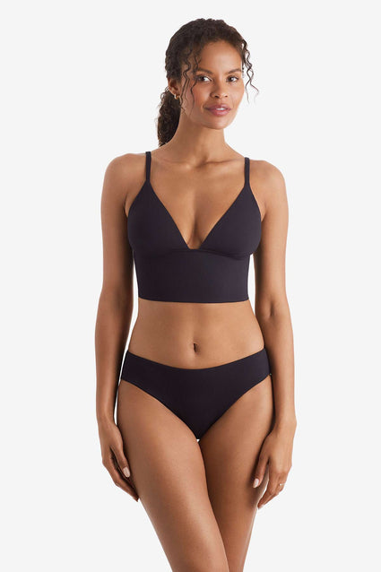 Woman wearing a black midkini swim top with black swim bottoms