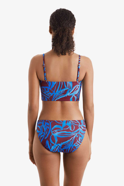 Woman faced away wearing a blue and brown abstract floral printed midkini swim top with matching swim bottoms