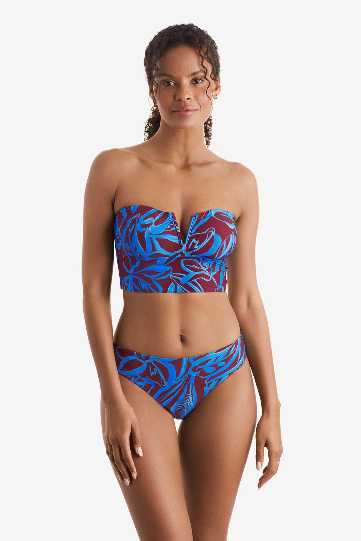 Woman wearing a blue and brown abstract floral printed midkini swim top with matching swim bottoms