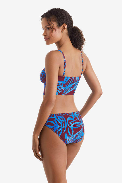 Woman faced left wearing a blue and brown abstract floral printed midkini swim top with matching swim bottoms