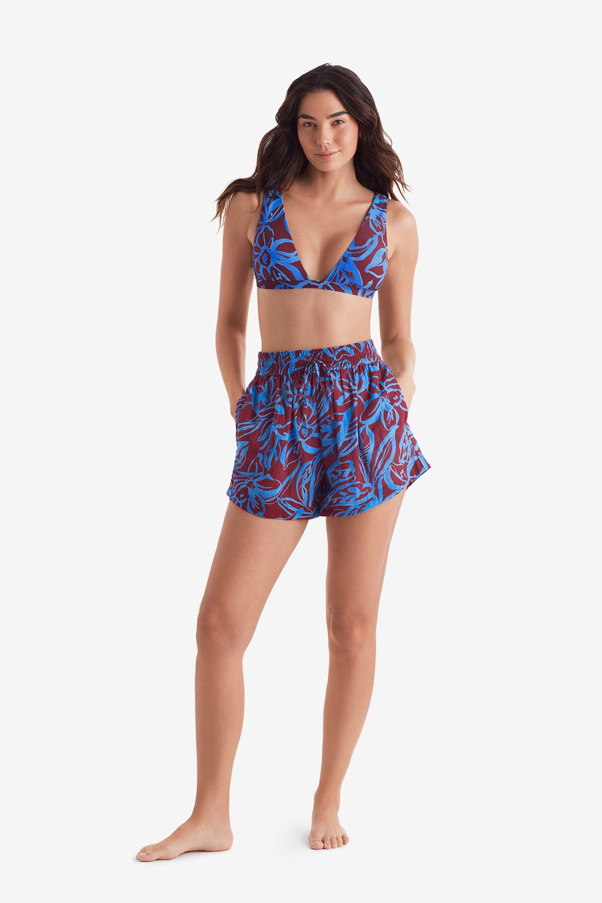 Woman wearing an abstract floral print bikini top with abstract floral print beach shorts