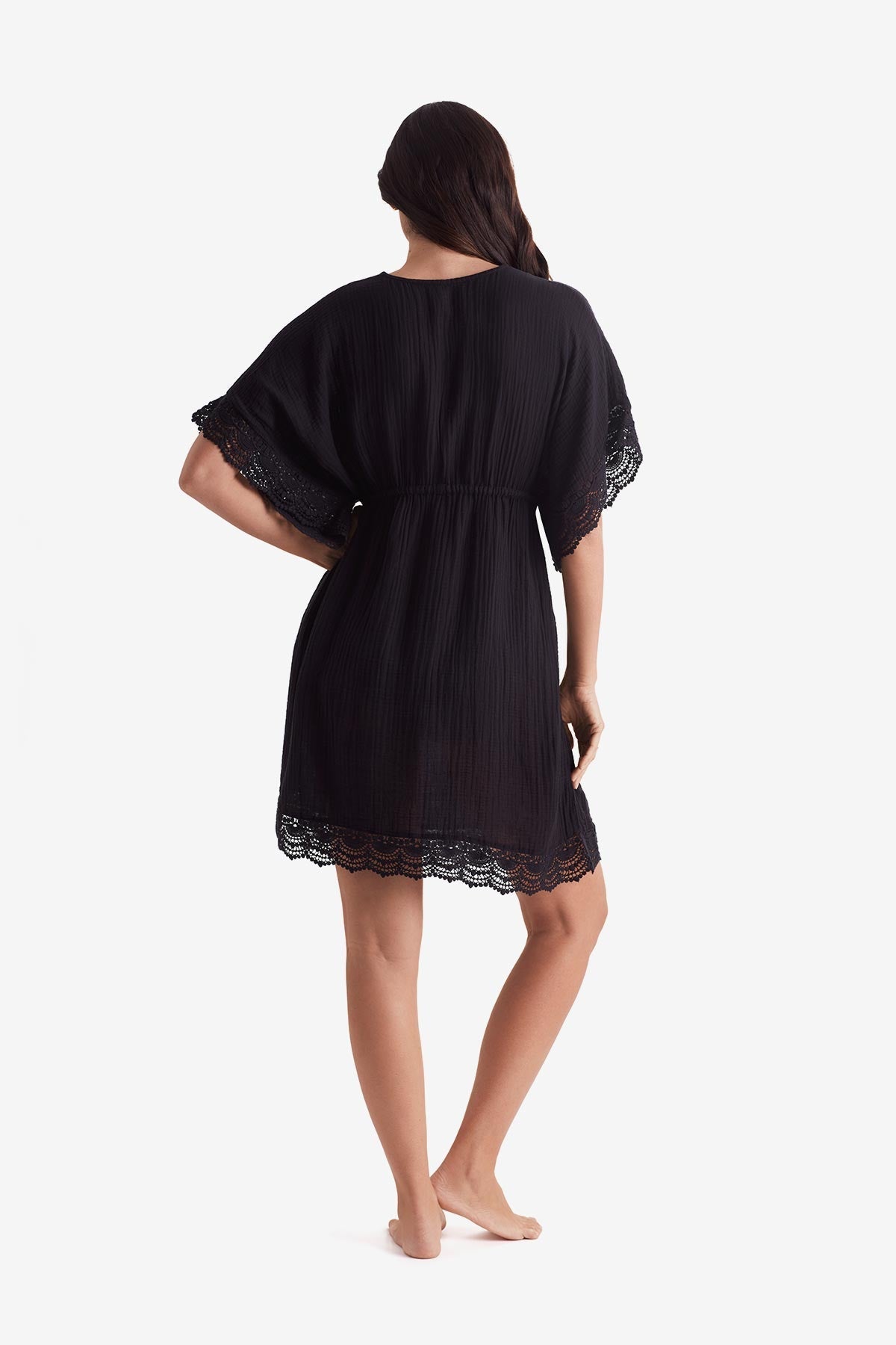 Woman turned away wearing a black tunic dress