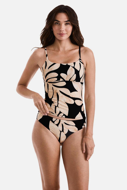 Woman wearing a large tan and black leaf printed tankini top with matching swim bottoms