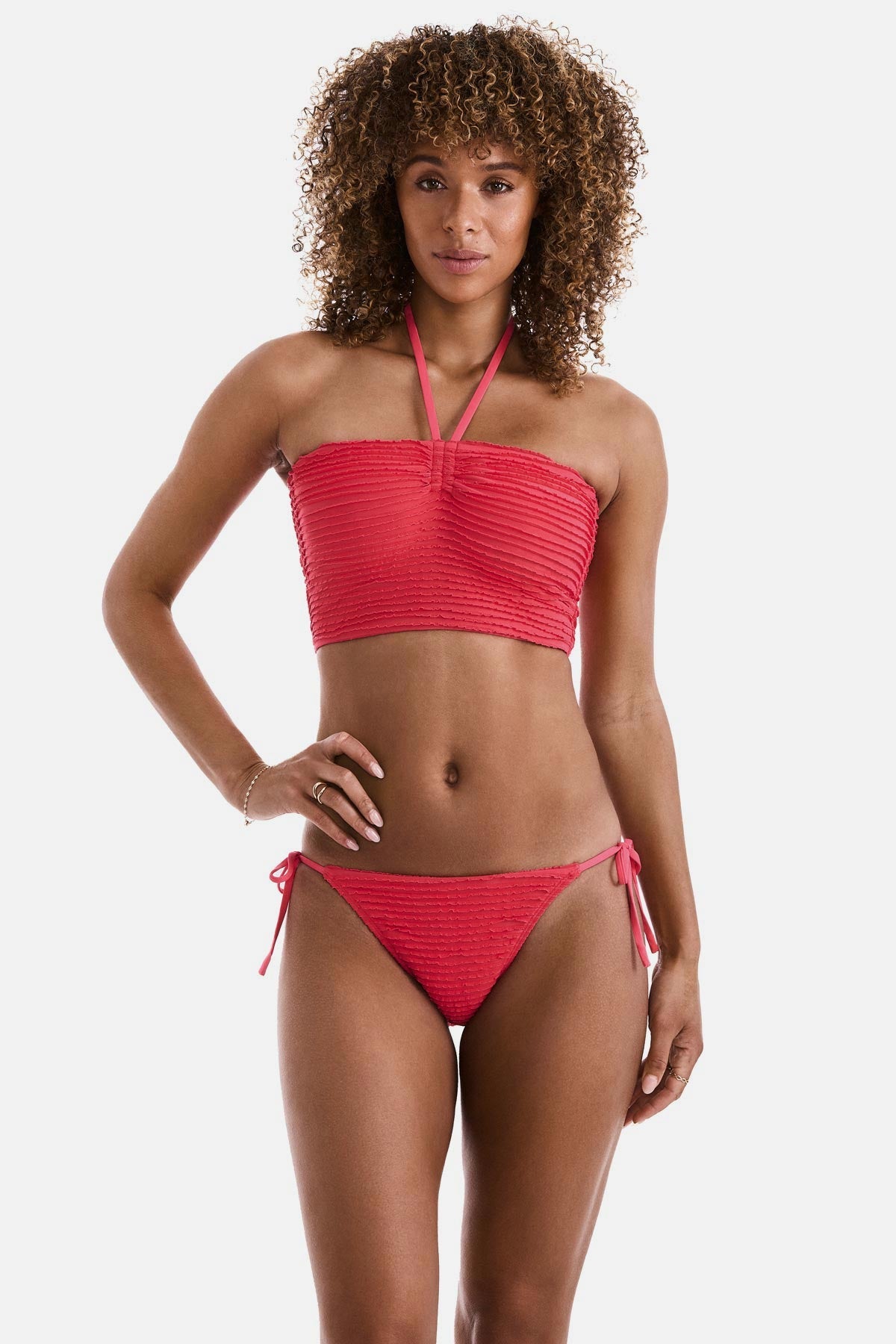 Woman wearing a coral colored midkini swim top with matching swim bottoms