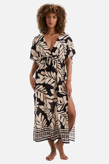Woman wearing a black and tan palm leaf printed swim dress cover up