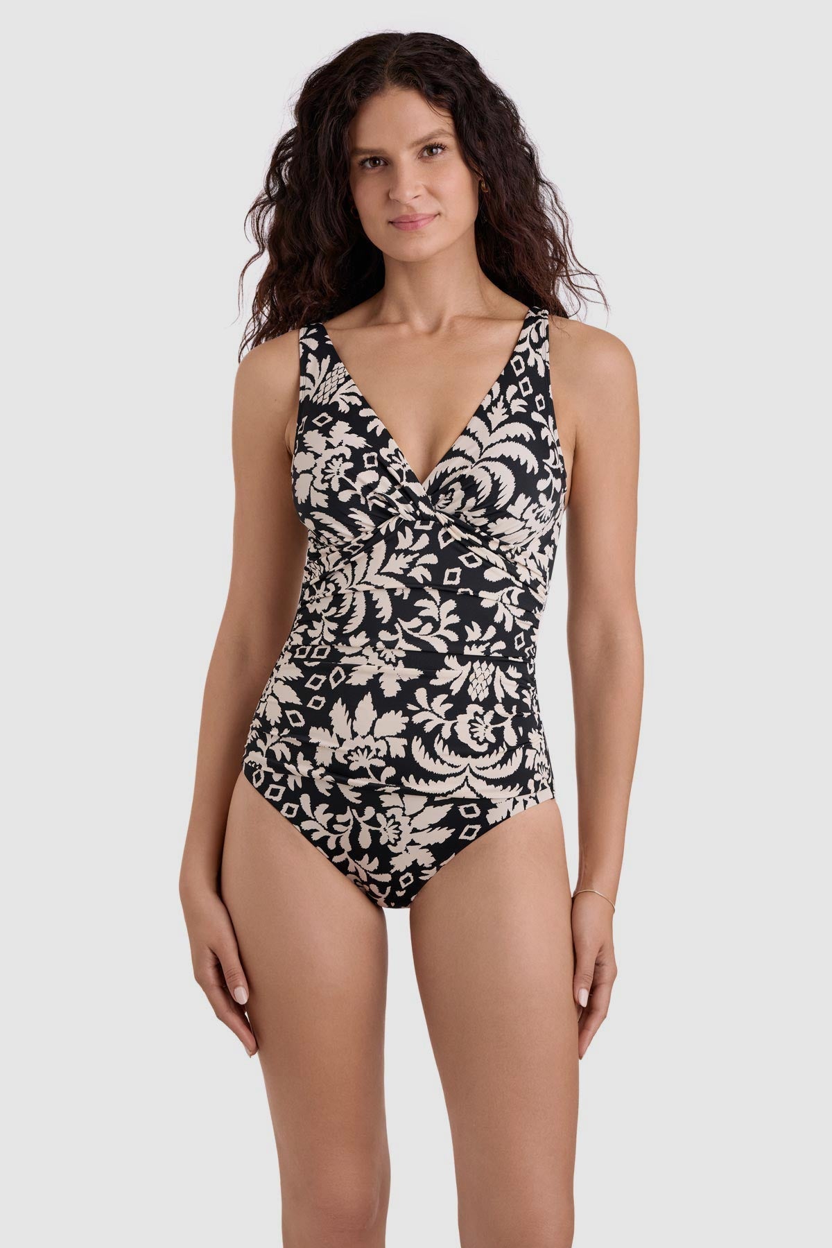 Woman wearing a black and white palm tree printed one-piece swimsuit