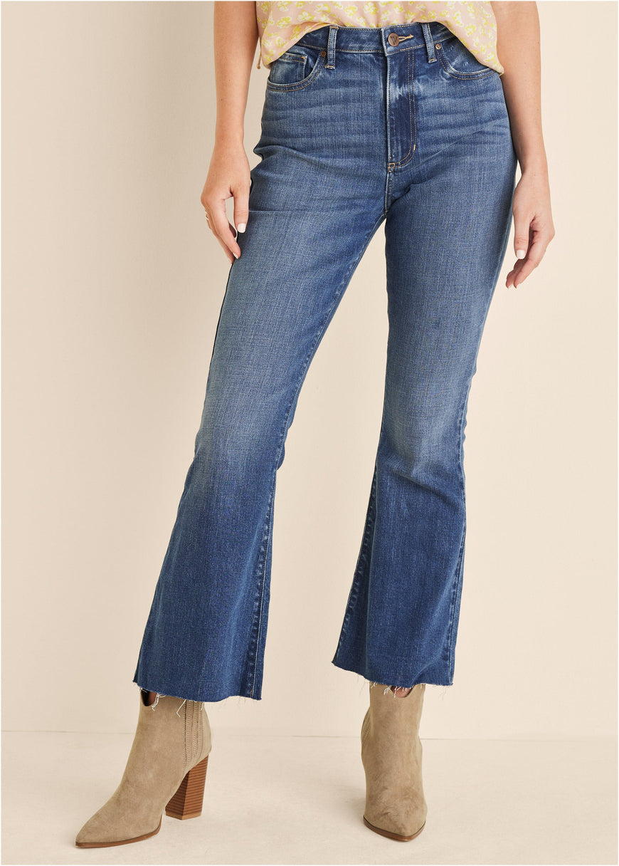 Woman in cropped flare jeans and heeled boots