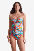 Woman wearing a multicolored floral bandeau tankini top with matching swim bottoms