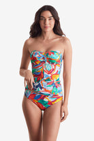 Woman wearing a multicolored floral bandeau tankini top with matching swim bottoms