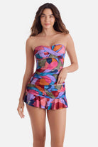 Woman wearing a bandeau style multicolored abstract print tankini top with matching skirted swim bottoms