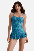 Woman wearing a blue abstract printed skirted one-piece swimsuit with straps