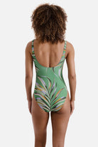 Woman turned away wearing a multicolored leaf printed one-piece swimsuit