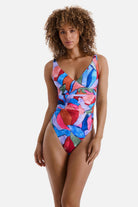Woman wearing a multicolored abstract print one-piece swimsuit