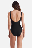 Woman turned away wearing a black one-piece swimsuit with a v neckline