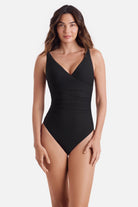Woman wearing a black one-piece swimsuit with a v neckline