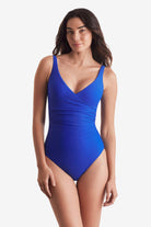 Woman wearing a blue one-piece swimsuit with a wide V neckline