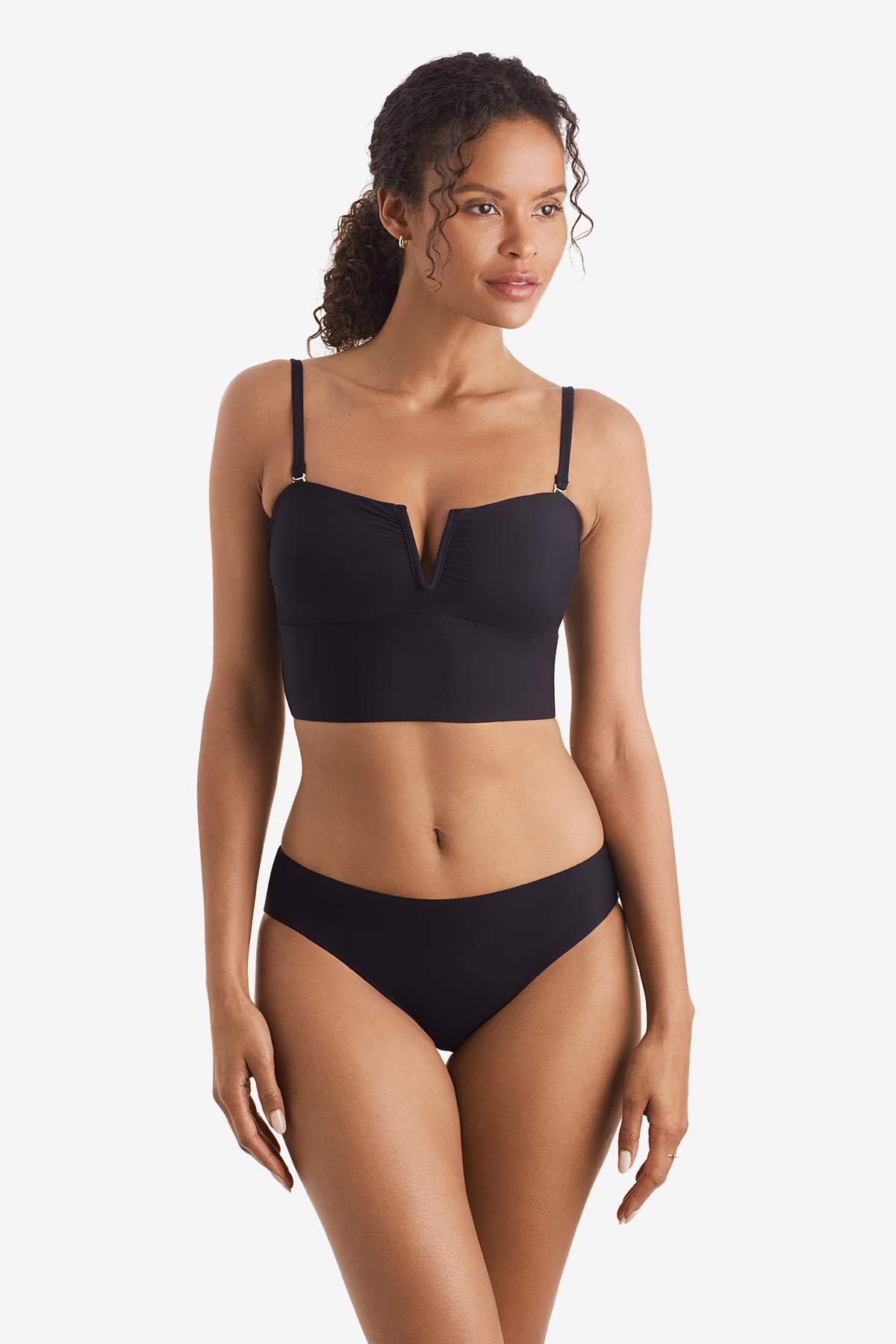 Woman wearing a black midkini swim top with black swim bottoms