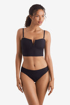 Woman wearing a black midkini swim top with black swim bottoms