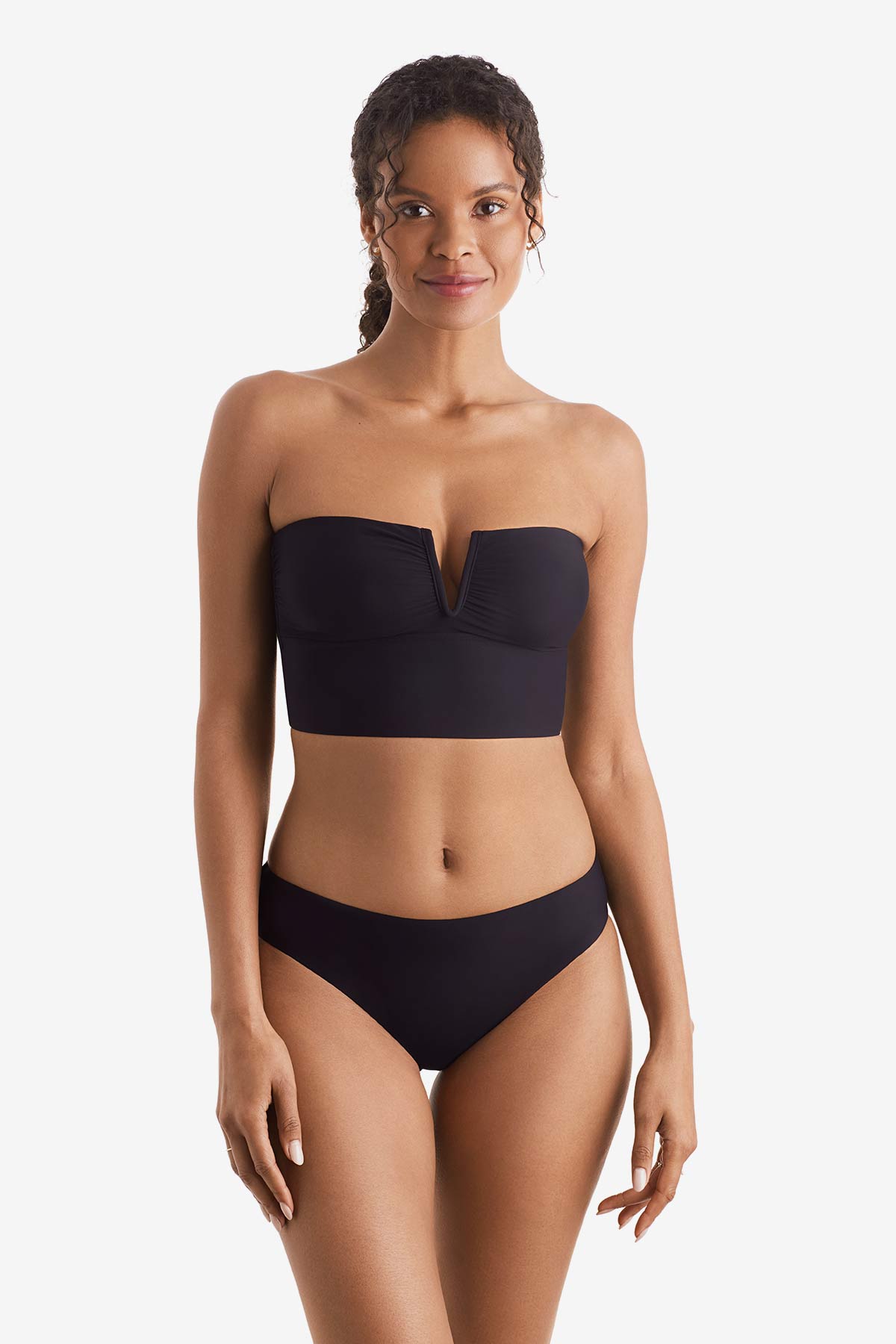 Woman wearing a black midkini swim top with black swim bottoms