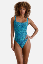 Woman wearing a blue abstract printed one-piece swimsuit