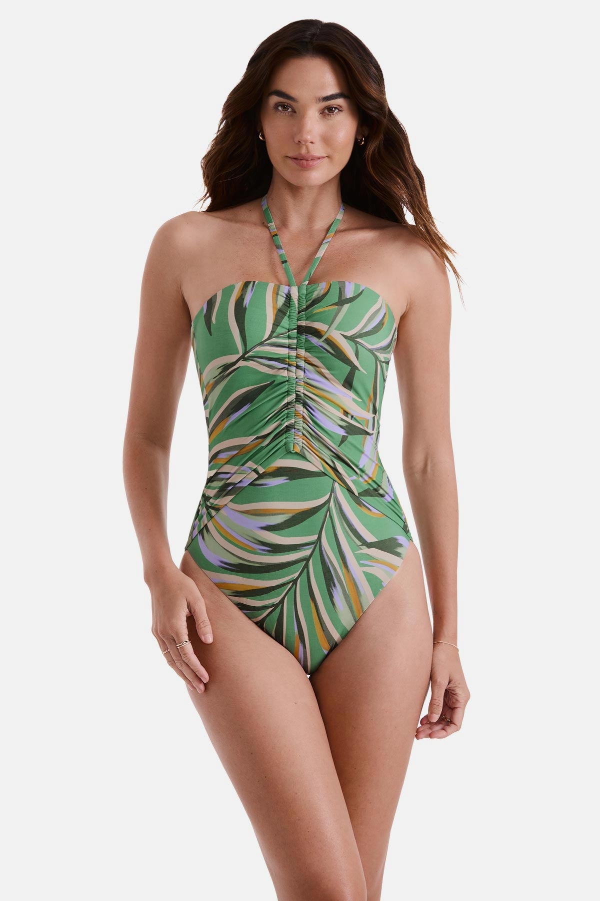 Woman wearing a multicolored leaf printed one-piece swimsuit with a halter tie