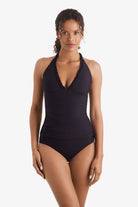 Woman wearing a black tankini top with ruffles on the neckline