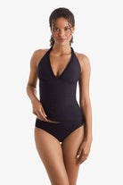 Woman wearing a black tankini top with ruffles on the neckline