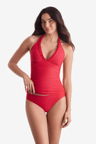 Woman wearing a pink-orange tankini top with matching swim bottoms