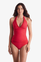 Woman wearing a pink-orange tankini top with matching swim bottoms