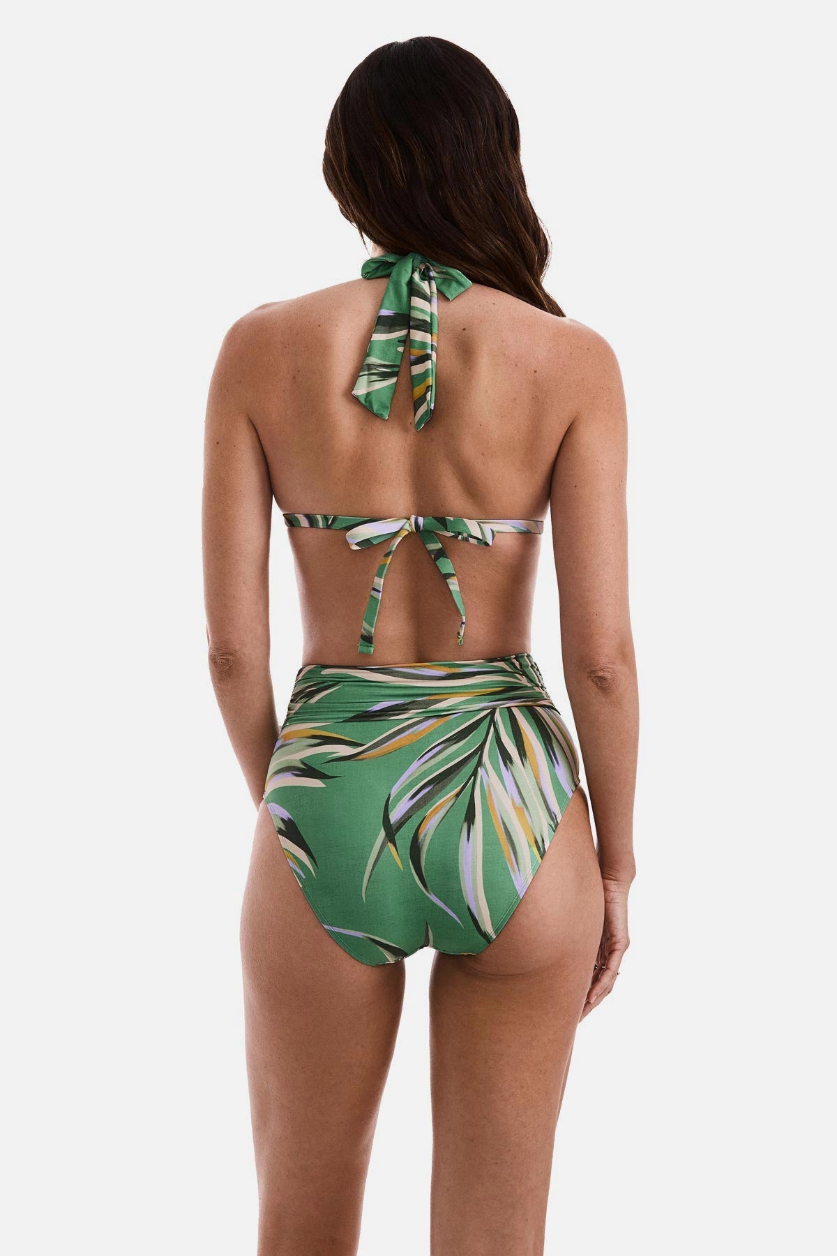 Woman turned away wearing a multicolored leaf printed bikini top and matching swim bottoms