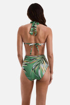 Woman turned away wearing a multicolored leaf printed bikini top and matching swim bottoms