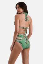 Woman turned left wearing a multicolored leaf printed bikini top and matching swim bottoms