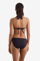 Woman faced away wearing a black bikini top with black swim bottoms