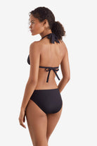 Woman faced left wearing a black bikini top with black swim bottoms