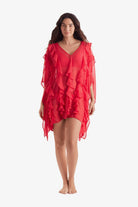 Woman wearing a sheer pink-orange swim dress cover up