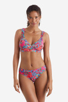 Woman wearing a multicolor paisley print bikini top with matching swim bottoms
