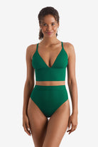 Woman wearing a green midkini swim top with matching high-waisted swim bottoms