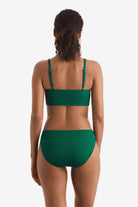 Woman turned away wearing a green rib fabric midkini swim top with green rib fabric swim bottoms