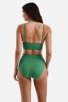 Woman turned away wearing a green ribbed midkini bralette swim top with matching swim bottoms