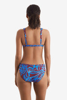 Woman turned away wearing a blue and brown abstract printed bikini top with match swim bottoms