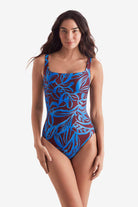 Woman wearing a blue and brown abstract floral print one-piece swimsuit