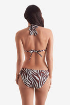 Woman turned away wearing a zebra print bikini top with zebra print swim bottoms