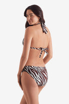Woman turned left wearing a zebra print bikini top with zebra print swim bottoms