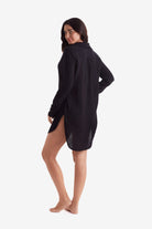 Woman faced left wearing a black long sleeve button up shirt 