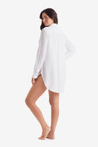 Woman turned left wearing a white long sleeve button up shirt