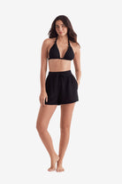 Woman wearing a black bikini top and black shorts